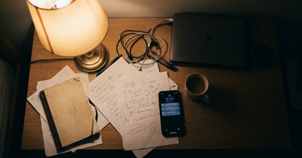 A cluttered desk with scattered documents and a smartphone, illustrating complexities of vendor relationships in startups.